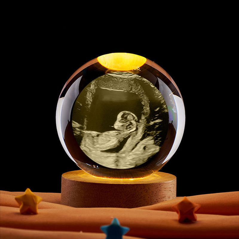 Pregnancy gift crystal ball with warm ambient light for nursery decor. Perfect for lifestyle shots in a nursery or bedside setting.